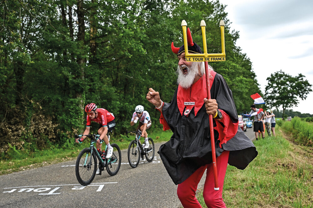 El fanático del ciclismo Didi Senft, más conocido como el Diablo, alienta a los ciclistas Benoit Cosnefroy, del equipo Citröen, y Anthony Delaplace, del equipo Arkea-Samsic, en la cuarta etapa del Tour. Foto: Marco Bertorello, AFP