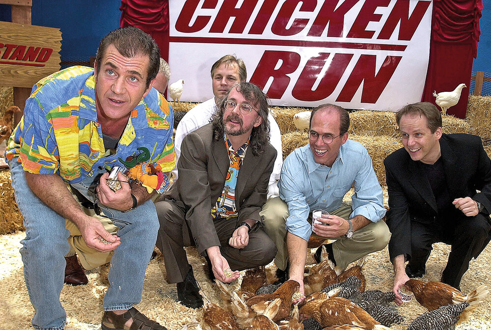 Mel Gibson, los directores Peter Lord y Nick Park, y el productor ejecutivo Jeffrey Katzenberg alimentan a las gallinas en el estreno de la película Chiken Run: Dawn of the Nugget, en Londres. Foto: Lucy Nicholson /AFP 