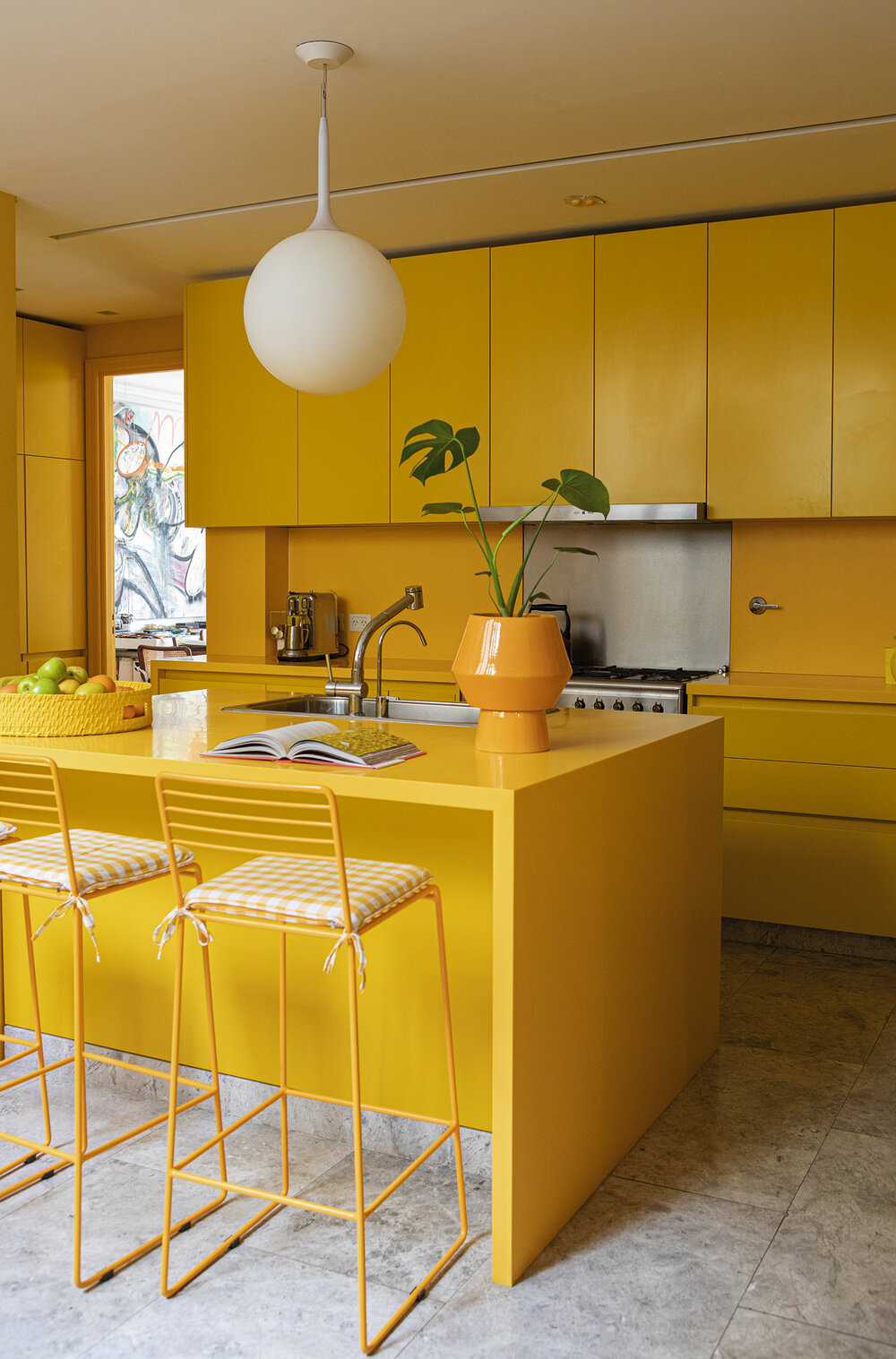 La cocina está dominada por el amarillo, presente en la mesada de Corian, sillas, aparadores y detalles que responden a la dinámica de la vida actual.