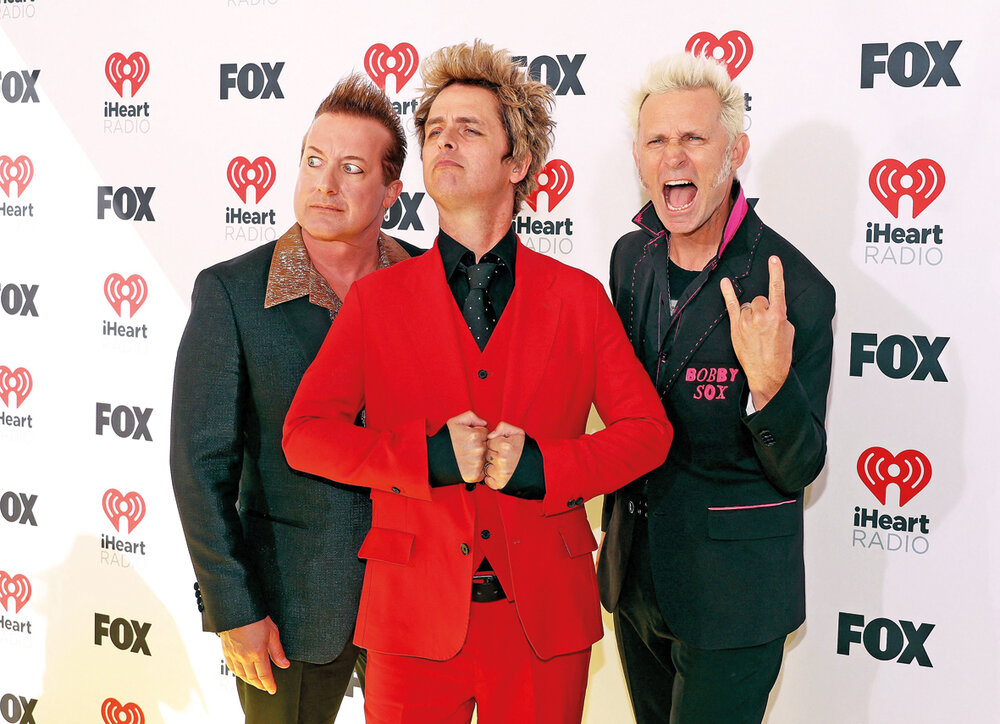 Tré Cool, Billie Joe Armstrong y Mike Dirnt, de Green Day, con su actitud habitual en los iHeart Radio Music Awards. AFP 
